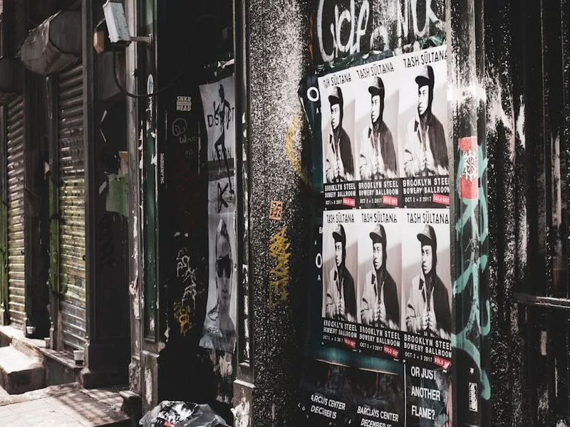 A street wall layered with community event posters — exactly the environment a QR code has to survive if it's going to get scanned months after printing.